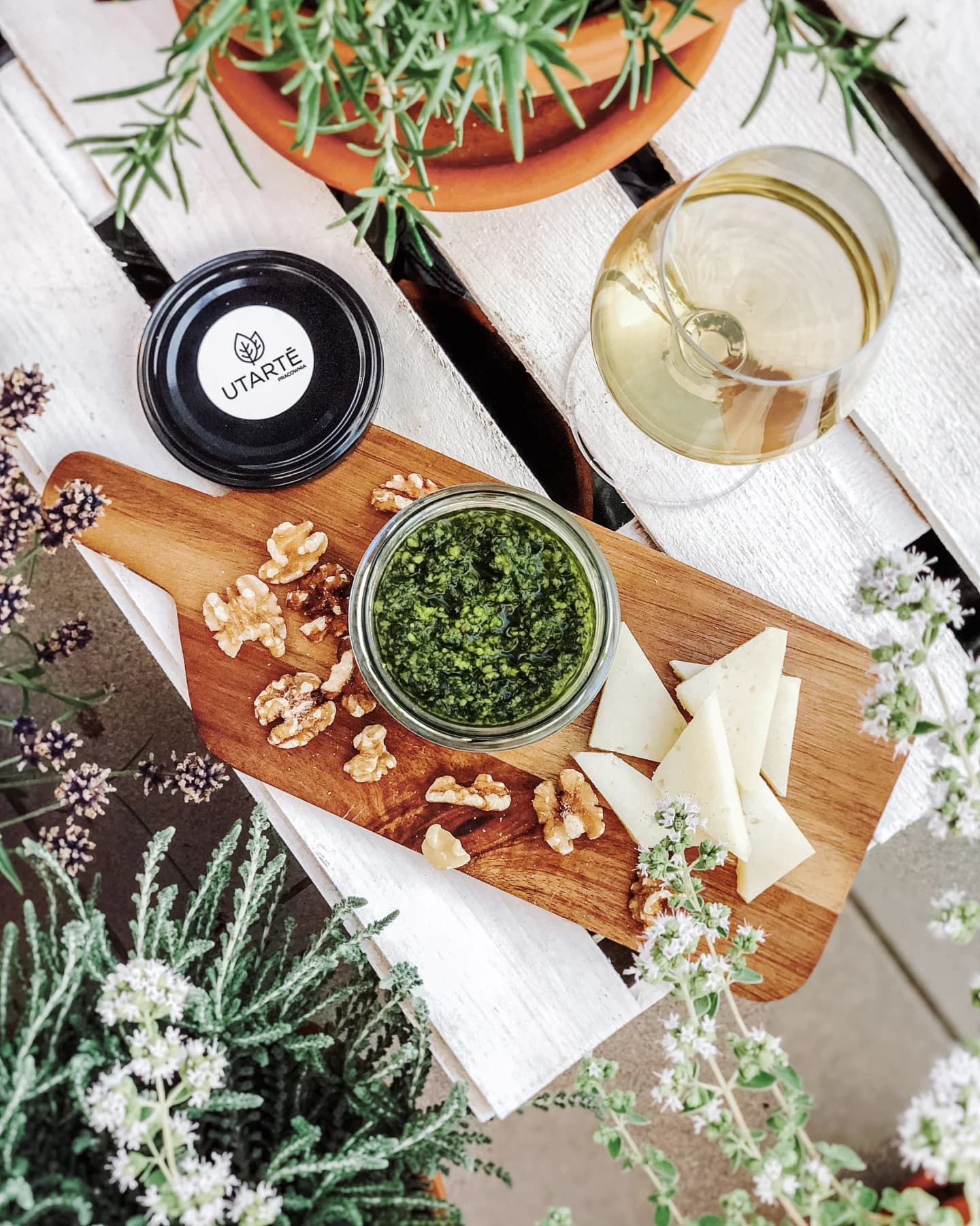 Słoik pesto Utarté podany z serem i kieliszkiem wina